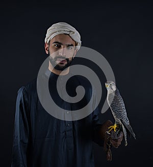 Young falconer holding a bird of prey.