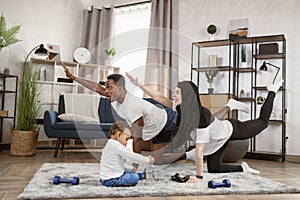 Young family african man and muslim arabic woman practising yoga stretching workout at home