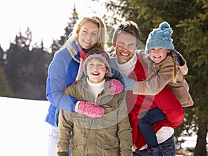 Young Family In Alpine Snow Scene