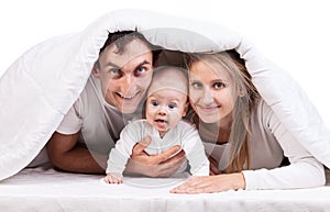 Young family with baby boy under blanket