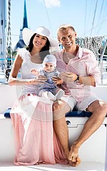 Young family with a baby on a sailing boat