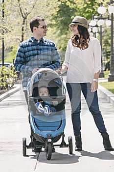 Young family with baby strollers on city walk