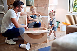 Young family after buying new house unpacking boxes