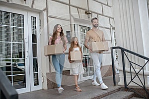 Young family carrying cardboards out of the house