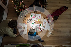 Young family celebrating Christmas making decorations