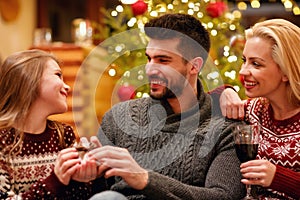 Young family celebrating and exchanging gifts Christmas at home