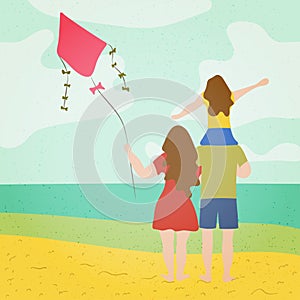 A young family with a child watching the sea on the beach with a kite in their hands. Summer season holiday vacation concept.