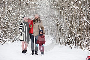 Young family with children are walking in the winter park. Winte