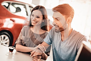 Young Family Are Choosing A New Car In Showroom.