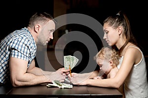 A young family counts money late in the evening.