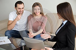 Young family couple with female broker discussing mortgage, prop