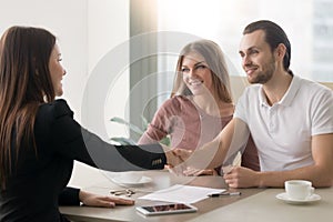 Young family couple meeting with broker, handshake symbolizing a photo