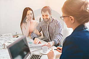 Young family couple purchase rent property real estate . Agent giving consultation to man and woman. Signing contract