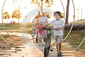 Young family cycling at the city park