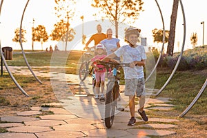 Young family cycling at the city park