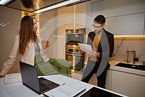 Young family discussing income and evaluating expenditure at home kitchen