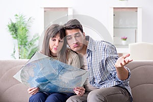 The young family discussing travel plans with map