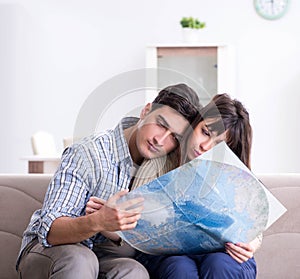 Young family discussing travel plans with map