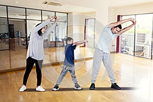 Young family doing stretching in fitness center