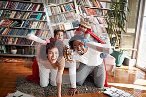 A young family enjoying and posing at home while imitating knights and horses. Family, home, love, together