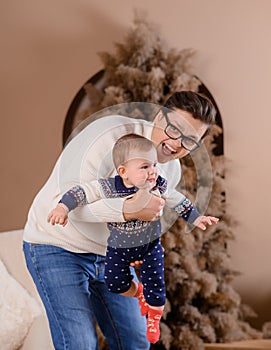 Giovane famiglia un un figlio battute un Pigro sul da nuovo un albero 