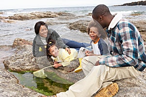 Young family with fishing net on rocks