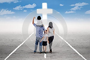 Young family follow a cross on the road