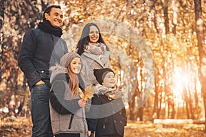 Young Family of Four Have Fun in Autumn Park.