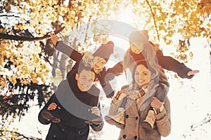 Young Family of Four Have Fun in Autumn Park.