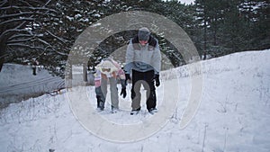 young family of four having fun in winter forest, parents and children cheerfully throw snowballs at each other