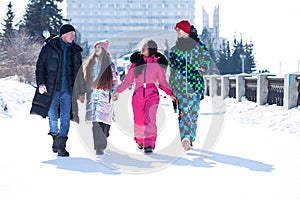 Young family of four walking outdoors in winter