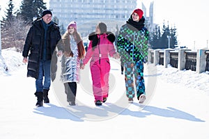 Young family of four walking outdoors in winter