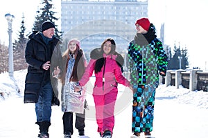 Young family of four walking outdoors in winter