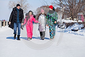 Young family of four walking outdoors in winter