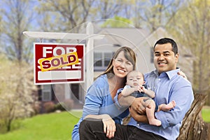 Young Family in Front of Sold Real Estate Sign and House