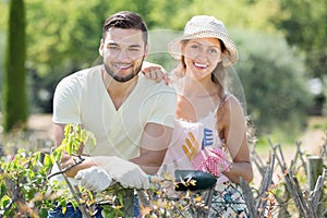 Young family in gloves in plants garden