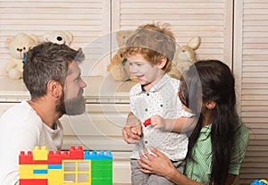 Young family with happy faces spending time together in playroom.