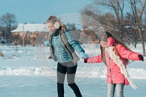 Young family have fun on the ice area in a snowy park