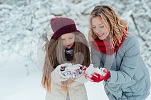 Young family have fun and make a snowman in a snowy park