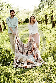 Young family having fun in apple orchard