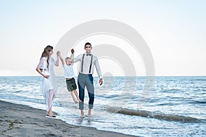 Young family having fun on the sea banks with young son. Family vacation concept