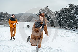 Young family having fun in winter snowy forest