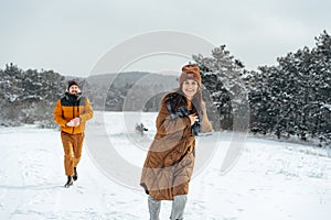 Young family having fun in winter snowy forest