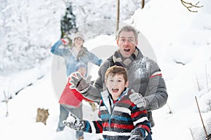 Young Family Having Snowball Fight