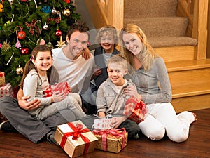 Young family at home exchanging gifts