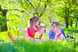 Young family with kids having picnic outdoors