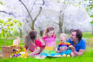 Young family with kids having picnic outdoors