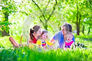 Young family with kids having picnic outdoors