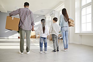 Young family with kids relocate with boxes to new house