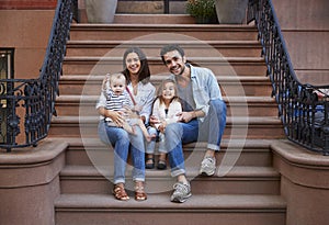 Young family with kids sitting on front stoops